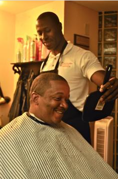 a man is getting his hair cut in a barber shop.