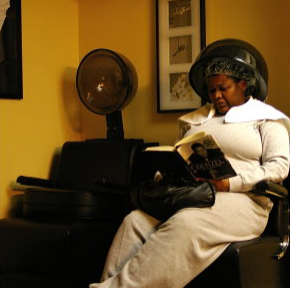 a woman sitting in a chair reading a book.