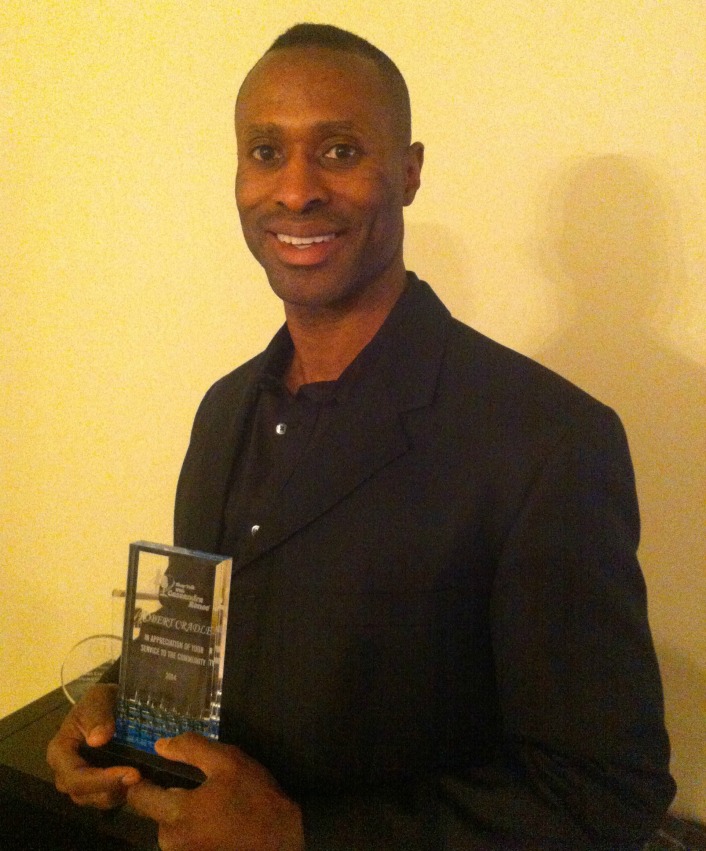 a man in a black suit holding an award.